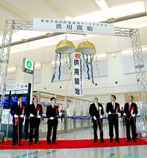那覇空港の新国際線ターミナルビルの運用開始を祝い、くす玉を割る関係者=17日