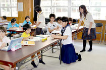制服姿の高校生指導員が、児童の勉強にアドバイスした=八島小学校