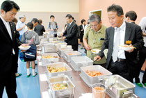 新給食センターで調理した食事を試食する中山市長(左)ら関係者=4日午後、同センター