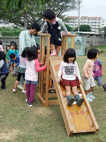 生徒たちの作った木製すべり台を滑る園児たち=22日午前、オリブ保育園
