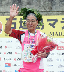 フルマラソン完走100回を達成した上間光明さん=22日午後、陸上競技場