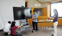 サテライトキャンパスの開設に向け、機材を調整する石垣市立図書館の職員=24日午後、同図書館