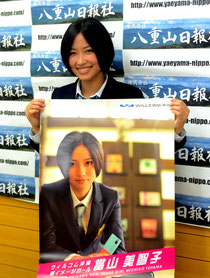 ポスターを手に「沖縄全体を當山ワールドに染めたい」と張り切る當山さん=八重山日報社