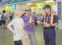 安全推進活動期間中、リーフレットを配布した海保官=2日午前、石垣港離島ターミナル