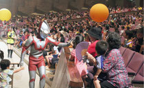 ウルトラマンに握手を求める子どもたち=29日午前、市民会館大ホール