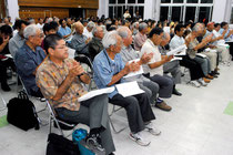 玉津教育長の早期辞任を求める決議を拍手で採択する集会参加者=22日夜、大川公民館