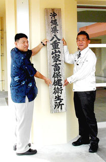 看板設置する玉城センター所長(右)、多良間所長