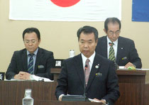 役場移転対策事業の議案訂正を行った川満町長=14日午前、町議場