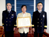 航行援助業務で表彰された仲宗根豊さん(中)=石垣海上保安部