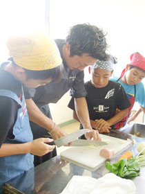 シェフ・原田さんの包丁さばきに、児童たちからは感嘆の声=26日午前、大浜小学校