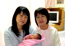 元旦に誕生した飯田さんの第2子。助産師の大底みどりさん(右)と一緒に=4日午後、県立八重山病院