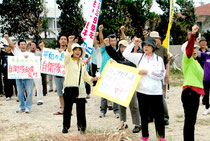 平和憲法を守る八重山連絡協議会が自衛隊の訓練に反対し、ガンバロー三唱した=9日午後、サザンゲートブリッジ入口付近