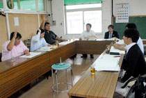 市議会総務財政委員会で一般会計予算案の採決が行われ、修正案に挙手して賛成する野党(左側)=19日午後、市役所