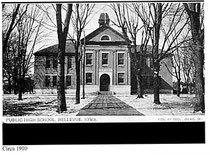 A photo of the building around 1910 with trees and cupola.