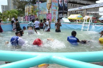 Niños jóvenes y adultos disfutando en las pestilentes aguas.  En la otra imagen la imagen del Alcalde Roberto Salcedo
