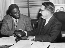 Jackie Robinson stringe la mano a Branch Rickey dopo la firma del suo primo storico contratto di major league baseball, 1945 @ Corbis