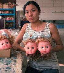 Chinoise présentant des poupées blondes aux visages de type européen