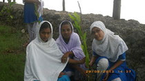 The river seen behind, often floods. They plant seedlings in praying for protecting their livelihood.