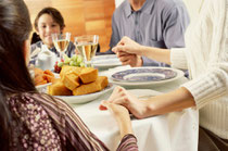 Family giving thanks around dining room table