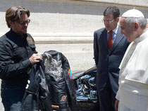 Papst Franziskus wirft einen Blick auf eine Motorradjacke. Foto: Osservatore Romano