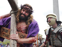 Sie schleppen große Holzkreuze und laufen den Leidensweg Jesu ab: Weltweit erleben Christen den Karfreitag hautnah mit. Foto: Andy Rain