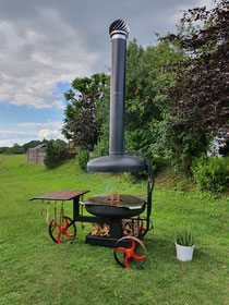 Ein Grill mit einer Feuerplatte, der auch als Feuerschale genutzt werden kann. Mit Zubehör verwandelt er sich in einen Pizzaofen, Smoker oder ist nutzbar für einen Dutch-Oven.