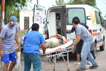 Vecinos ayudando al chofer de la ambulancia para socorrer a un accidentado