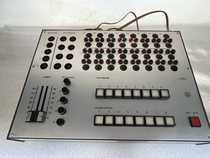 Telefunken U 250 NF Verteilerpult in Metallausführung. Frontansicht mit Anschlussmatrix für Verstärker V1–V8 und Lautsprecher L1–L8. Linke Seite mit zweikanaliger Pegelanzeige und Doppel-Schieberegler. Untere Reihe mit beleuchteten Drucktasten zur Umschaltung von Verstärkern und Lautsprechern. Rote Netz-Ein-Aus-Taste rechts.
