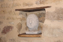 sculpture d'un visage humain installé dans un niche du mur