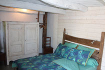 chambre dans une ambiance vintage avec poutres apparentes et meuble revisité