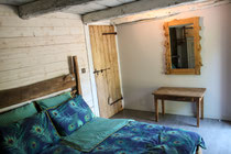 chambre avec lit 2 places table porte-valise miroir et porte ancienne