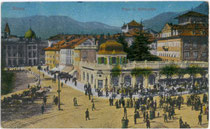 Sonntagscorso am Pfarrplatz (links) und angrenzendem Waltherplatz (rechts) in Bozen (heute Landeshauptstadt von Südtirol). Farblichtdruck 9 x 14 cm; Impressum: Joh(ann). F(ilibert). Amonn, Bozen 1913.  Inv.-Nr. vu914fld00004