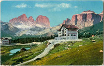 Hotel „Pordoi“ (2.140 m) an der Dolomitenstraße in Canazei im Fassatal (1868-1919 Bzk. Cavalese, Gef. Grafsch. Tirol) mit Langkofel (3.178 m) und Sella (3.152 m). Photochromdruck 9 x 14 cm; Impressum: Joh. F. Amonn, Bozen 1909.  Inv.-Nr. vu914pcd00265