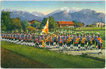 Musik- und Schützenzug der k.k. Standschützenkompanie von Oberperfuß, Bezirk Innsbruck-Land, Tirol in Marschformation aufgestellt. Photochromdruck 9 x 14 cm; Impressum: Wilhelm Stempfle, Innsbruck; postalisch befördert 1916.  Inv.-Nr. vu914pcd00321