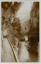 Steg über die Brandenberger Ache am Ende der Gschössklamm (heute: Tiefenbachklamm) und Triftsteig (im Vordergrund) in Brandenberg, Bezirk Kufstein, Tirol. Gelatinesilberabzug 10 x 15 cm ohne Impressum, um 1907.  Inv.-Nr. vu105gs00099