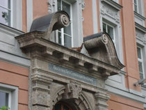 Portalaufsatz mit Voluten im Mittelrisalit vom Akademischen Gymnasium in Innsbruck, Angerzellgasse 14 (errichtet 1909/10). Digitalphoto, © Johann G. Mairhofer 2012.  Inv.-Nr. 1DSC04253