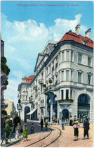 Gleiskörper der Grieser Linie der Straßenbahn Bozen bei der Abzweigung von der Goethestraße (vorne) in die Defreggerstraße (hinten) mit dem „Colonnadenhof“. Photochromdruck 9 x 14 cm; Joh(ann). F(ilibert). Amonn, Bozen 1910.  Inv.-Nr. vu914pcd00095