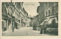 Via Roma (vormals/già via Lunga) in Trento (dt.: Trient). Lichtdruck 9 x 14 cm; Impressum: G. P. M. (?) ohne Angabe des Verlagsortes, handschriftl. dat.: 9.11.1922.  Inv.-Nr. vu914ld00301