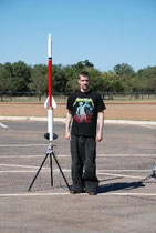Daniel next to a semi-scale Terrier-Sandhawk built from a plotter paper core tube and a mailing tube