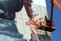 Fintan Magee, aus Australien, bei der Arbeit an einem großen Mural....