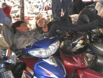 Asiaten koennen ueberall schlafen und entspannen. Mittagspause auf dem Moped. 