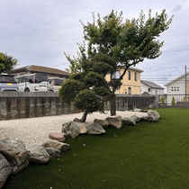 既存の景石を利用して、雑草対策を敷地全面に施した人工芝の庭園ができました。
