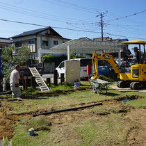 芝を剥ぎ取り土を掘削、透水シートにくるんだパーライトと暗渠配管を埋設します。