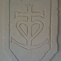 Sur mur de terrasse, croix camarguaise sur son blason avec des remparts
