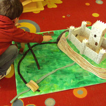 Atelier château : construction d'une maquette de site castral avec château (vocabulaire : donjon, remparts...), routes et village autour