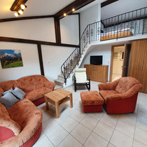 Studio Wohnzimmer mit Couch, Aufgang obere Etage mit Schlafzimmer