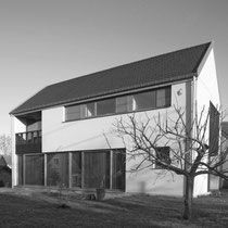 Habitation unifamiliale - Matériaux : Crépi et bardage ajouré en bois.