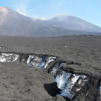 L'Etna - Congère de neige recouverte de cendres? La cendre froide est super isolante et empêche la neige de fondre.