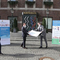 Scheckübergabe vor dem Rathaus