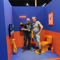 Das Bild zu Männerquatsch Podcast Folge 197 zeigt das Team von Simple Siegen in der Retro Area auf der Gamescom 2025.